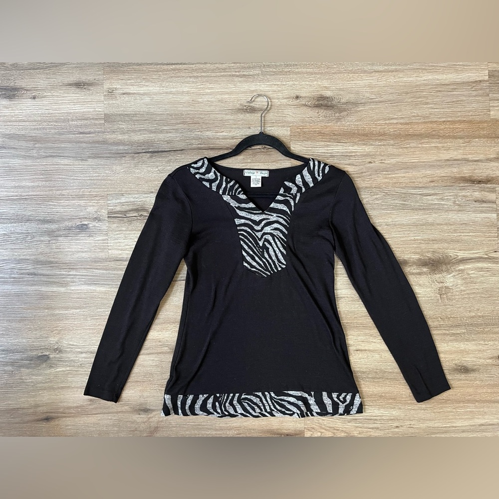 Size is 8. Solid black long sleeve shirt with design.